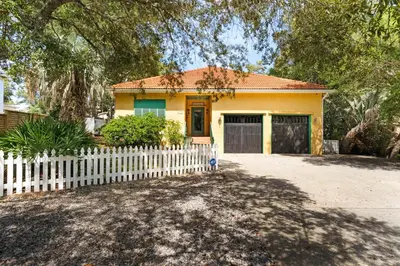 a yellow house with a white picket fence at Little Narnia - Colorful Beach House Private Pool in Seacrest