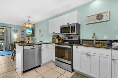 a kitchen with white cabinets and stainless steel appliances at Sunny Daze at Beachwood Villas - Walk to Beach Outdoor Pools & More in Santa Rosa Beach