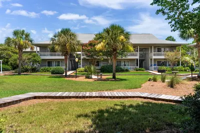 a large house with palm trees in front of it at Sunny Daze at Beachwood Villas - Walk to Beach Outdoor Pools & More in Santa Rosa Beach