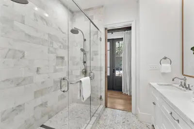 a bathroom with a glass shower and a sink at Rosemary Bluegrass in Rosemary Beach
