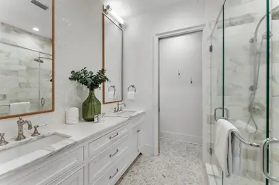 a white bathroom with two sinks and a shower at Rosemary Bluegrass in Rosemary Beach