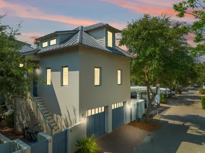 a house with a fence in front of it at Piccadilly Carriage House in Rosemary Beach