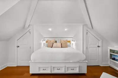 a white bedroom with a white bed with pillows at Piccadilly Carriage House in Rosemary Beach