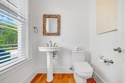 a white bathroom with a toilet and a sink at Pinecrest Retreat in Inlet Beach