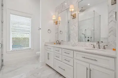 a white bathroom with a sink and a mirror at Pinecrest Retreat in Inlet Beach
