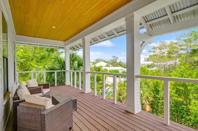 a screened porch with a couch and chairs on it at Pinecrest Retreat in Inlet Beach