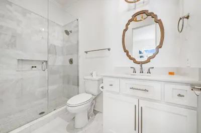 a bathroom with a toilet and a shower and a mirror at Pinecrest Retreat in Inlet Beach