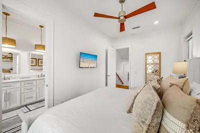 a white bedroom with a bed and a ceiling fan at Pinecrest Retreat in Inlet Beach