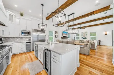 a kitchen with white cabinets and a living room at Pinecrest Retreat in Inlet Beach
