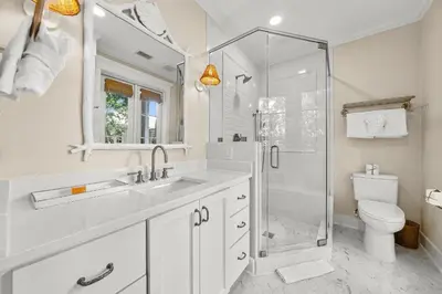 a bathroom with a shower and a sink and a toilet at Piccadilly Cottage in Rosemary Beach