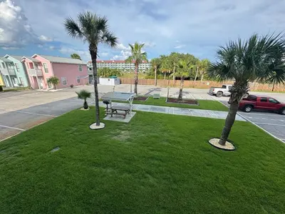a park with a bench and palm trees in a street at Beach Across Street, Walk to Restaurants, 2 Pools, Beach Gear in Panama City Beach