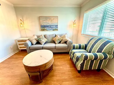 a living room with a couch and a coffee table at Beach Across Street, Walk to Restaurants, 2 Pools, Beach Gear in Panama City Beach