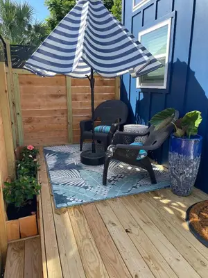 a patio with two chairs and an umbrella at The Blue Umbrella at the Beach in Panama City Beach