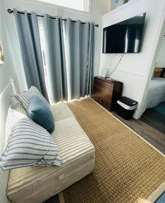 a bedroom with a bed with blue pillows and a television at The Blue Umbrella at the Beach in Panama City Beach
