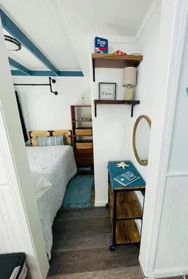 a small bedroom with a bed and a table at The Blue Umbrella at the Beach in Panama City Beach