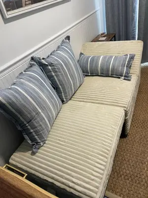a couch with two pillows on it in a room at The Blue Umbrella at the Beach in Panama City Beach