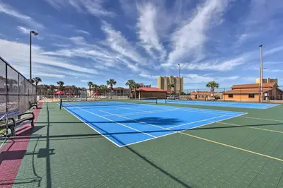 a tennis court with a blue tennis court at Cheerful 1-bedroom townhouse with spacious loft in Panama City Beach
