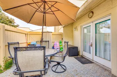 a patio with a table and chairs and an umbrella at Cheerful 1-bedroom townhouse with spacious loft in Panama City Beach
