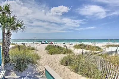 a sandy beach with a palm tree and the ocean at Cheerful 1-bedroom townhouse with spacious loft in Panama City Beach