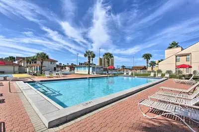 a large swimming pool with chairs in a resort at Cheerful 1-bedroom townhouse with spacious loft in Panama City Beach