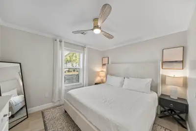 a white bedroom with a bed and a window at Beachside Villas 811 in Watersound Beach