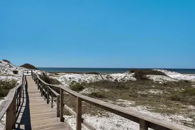 a wooden boardwalk leading to a beach with the ocean at Beachside Villas 811 in Watersound Beach
