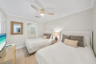 a bedroom with two beds and a flat screen tv at Beachside Villas 811 in Watersound Beach