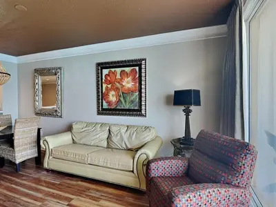 a living room with a couch and a chair at Majestic Beach Towers II #1806 in Panama City Beach