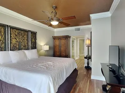 a bedroom with a bed with a ceiling fan and a television at Majestic Beach Towers II #1806 in Panama City Beach