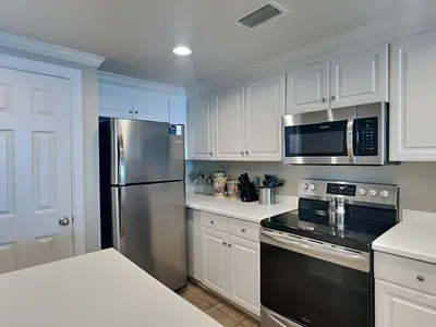 a kitchen with white cabinets and a stainless steel refrigerator at Majestic Beach Towers II #1806 in Panama City Beach
