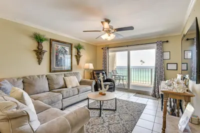 a living room with a couch and a ceiling fan at Beach and Pool Access Regency Towers Condo in PCB! in Panama City Beach