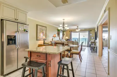 a kitchen with a refrigerator and a table and chairs at Beach and Pool Access Regency Towers Condo in PCB! in Panama City Beach