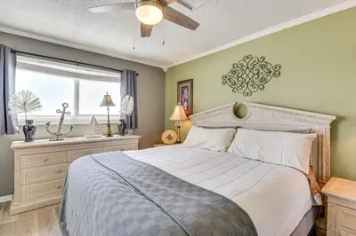 a bedroom with a large bed and a window at Beach and Pool Access Regency Towers Condo in PCB! in Panama City Beach