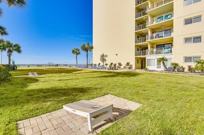 a park with a bench in front of a building at Beach and Pool Access Regency Towers Condo in PCB! in Panama City Beach