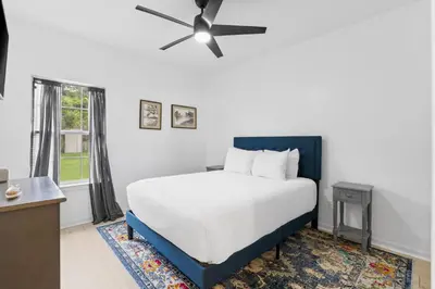 a bedroom with a bed and a ceiling fan at Pet Friendly Beach House - Baby Blue Heron by Panhandle Getaways in Panama City Beach