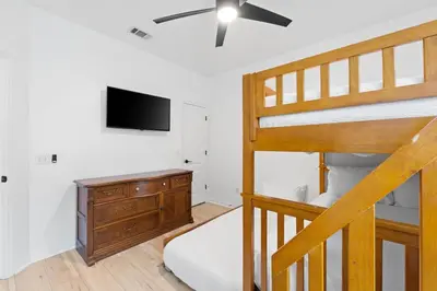 a bedroom with a bunk bed and a tv at Pet Friendly Beach House - Baby Blue Heron by Panhandle Getaways in Panama City Beach
