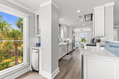 a kitchen with white cabinets and a large window at A115 The Fuller View at Watersound in Santa Rosa Beach