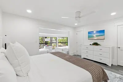 a white bedroom with a large white bed and windows at Wise Choice on 30A in Santa Rosa Beach