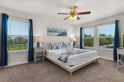 a bedroom with a bed and a ceiling fan at Shell We Stay (3/2.5) in Panama City Beach