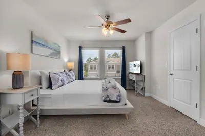 a bedroom with a bed and a ceiling fan at Shell We Stay (3/2.5) in Panama City Beach
