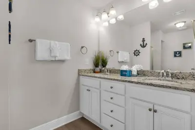 a bathroom with a sink and a large mirror at Shell We Stay (3/2.5) in Panama City Beach