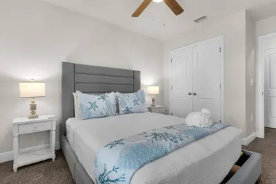 a bedroom with a large bed and two lamps at Shell We Stay (3/2.5) in Panama City Beach