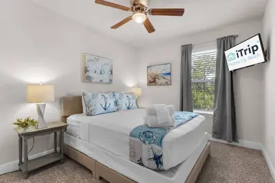 a bedroom with a bed and a ceiling fan at Shell We Stay (3/2.5) in Panama City Beach
