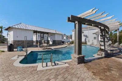 a swimming pool with an arbor and an outdoor swimming pool at Shell We Stay (3/2.5) in Panama City Beach