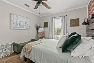 a bedroom with a bed and a chair and a window at Down By The Bay St Andrews Gem in Panama City
