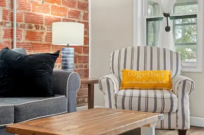 a living room with a couch and a chair with a pillow at Down By The Bay St Andrews Gem in Panama City