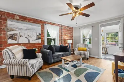 a living room with a brick wall and a ceiling fan at Down By The Bay St Andrews Gem in Panama City