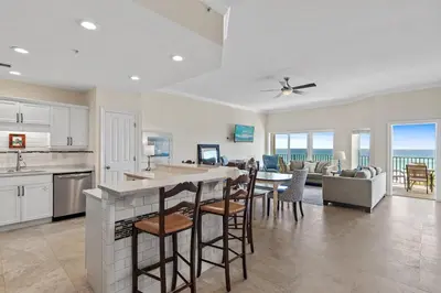 a kitchen and living room with a view of the ocean at Legacy 202 in Santa Rosa Beach