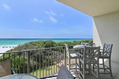 a balcony with chairs and a table and the beach at Legacy 202 in Santa Rosa Beach