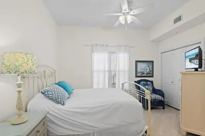 a white bedroom with a bed and a ceiling fan at Legacy 202 in Santa Rosa Beach